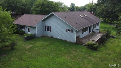Rear view of property featuring a wooden deck, roof with shingles, and a chimney