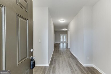 Hall with light wood finished floors and baseboards