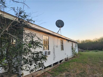Property exterior at dusk featuring a yard and cooling unit