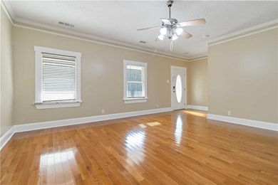 Empty room featuring ornamental molding, light wood-type flooring, ceiling fan, and a textured ceiling