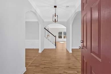 Foyer featuring stairway, ornamental molding, ligh