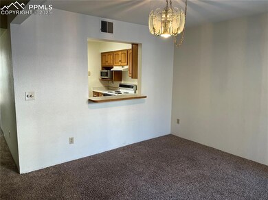 Unfurnished room featuring a chandelier and carpet