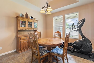 Dining area featuring baseboards and a chandelier
