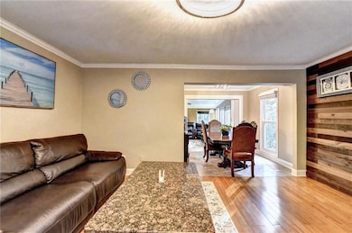 Living area with light wood finished floors, baseb