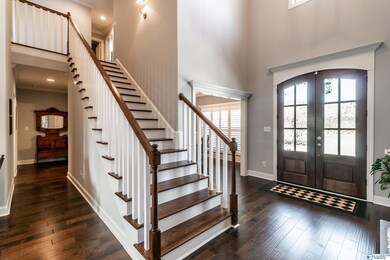 Double front doors and wood staircase are just two