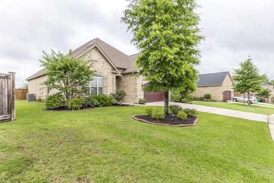 French country style house featuring concrete driveway, brick siding, and central air condition unit