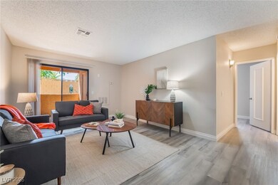 Living room featuring baseboards, a textured ceili