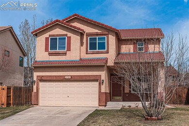 View of front of property featuring stucco siding, a tile roof, and fence