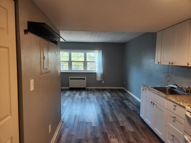 Kitchen with white range oven, white cabinetry, si