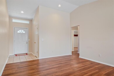 Foyer featuring light tile floors and lofted ceili