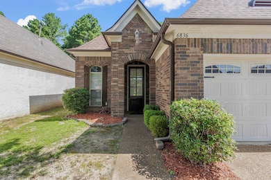 Entrance to property with brick siding, an attached garage, and roof with shingles