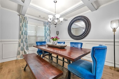 Dining room with coffered ceiling, a chandelier, w