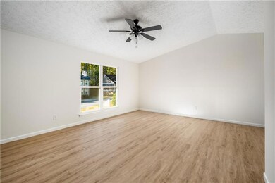 Spare room featuring lofted ceiling, a ceiling fan