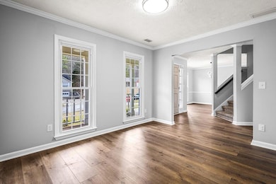 Empty room featuring stairway, dark wood-style flo