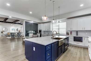 Kitchen with white cabinets, light hardwood / wood