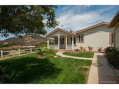 The covered porch looks out to panoramic views and grassy area in front of the home.