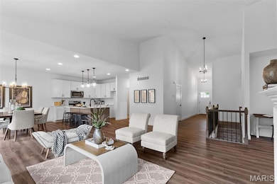 Living area featuring a chandelier, dark wood-style flooring, recessed lighting, and high vaulted ceiling