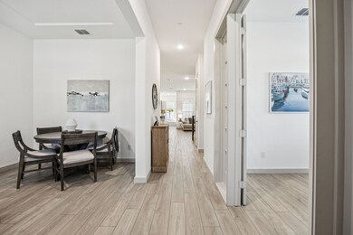 Corridor with light wood-style flooring and recessed lighting