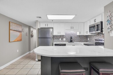 Kitchen featuring backsplash, appliances with stai