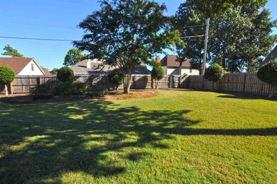 The backyard is surrounded by a wood privacy fence