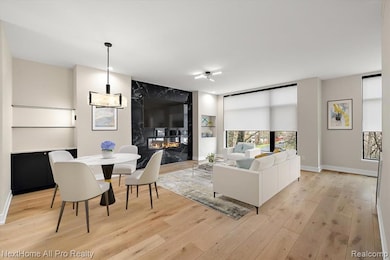 Living room and Dining Room featuring a premium fireplace and light wood-style flooring