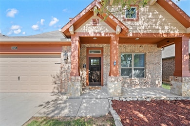 Craftsman house featuring covered porch, driveway, brick siding, and an attached garage