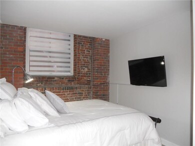 Bedroom with exposed brick wall and...