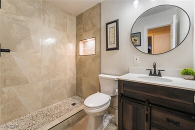 Bathroom with vanity, toilet, and a tile shower