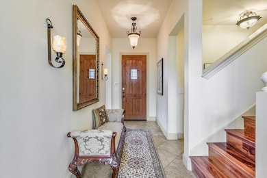 Entrance foyer featuring stairway, light tile pat