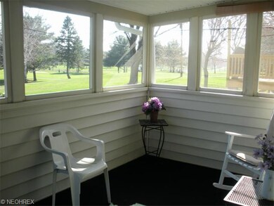 The screened rear porch offers a view of Ridgewood Country Club golf course.