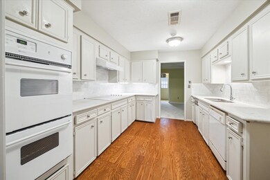Sleek granite countertops and ample cabinetry make
