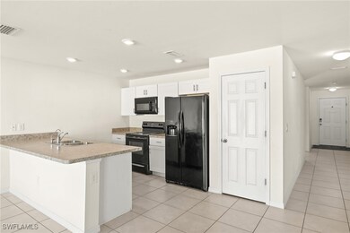 Kitchen featuring black appliances, a sink, white