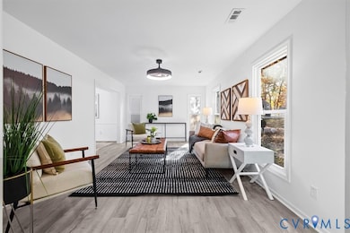 Living room with light wood-type flooring and baseboards