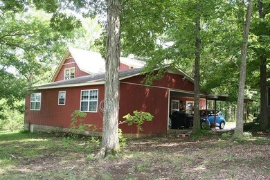 Back view of home with covered carport. Garage is to the right. 2 back door entrances.