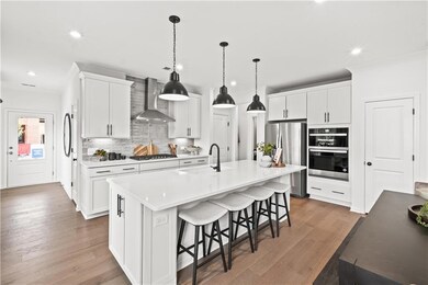 Kitchen with a kitchen breakfast bar, decorative backsplash, recessed lighting, appliances with stainless steel finishes, and crown molding