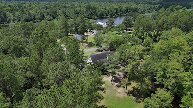 Aerial overview of property's location featuring a heavily wooded area and a large body of water