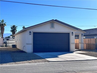 View of front of property with a garage, stucco siding, and an outdoor structure