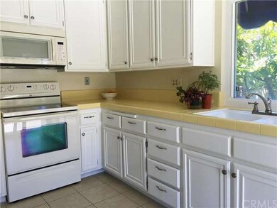 LONG TILE COUNTERS, FRESHLY PAINTED CABINETS