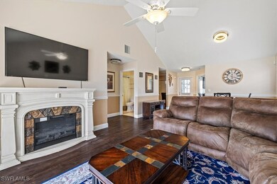 Living room featuring a tiled fireplace, ceiling f