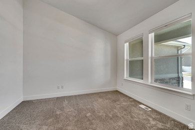 Empty room featuring carpet and baseboards