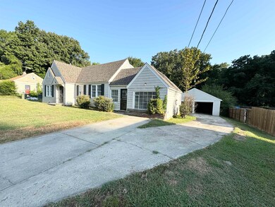 Ranch-style home with a garage, an outbuilding, an