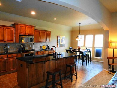 The kitchen features granite countertops & a tumbl