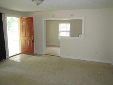Living room offers neutral carpet and paint color.  This view shows unique entry  into the eating area.
