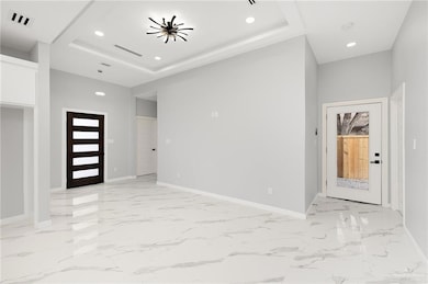 Foyer featuring a tray ceiling and french doors
