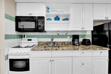 Kitchen with black appliances, sink, backsplash, w