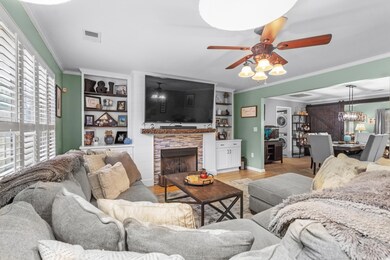 Living room with crown molding, ceiling fan, light