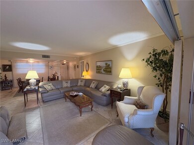 Living room featuring crown molding and tile patterned floors