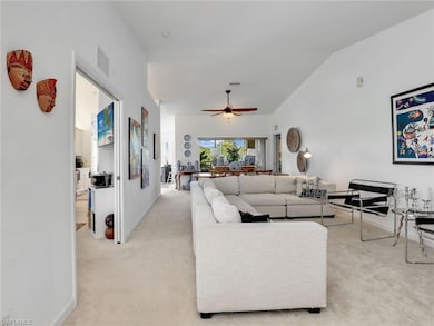 Living room featuring ceiling fan, light carpet, a