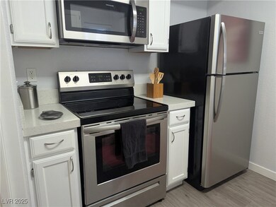 Kitchen with stainless steel appliances, light woo