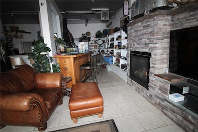 Tiled living area with a stone fireplace and a bar